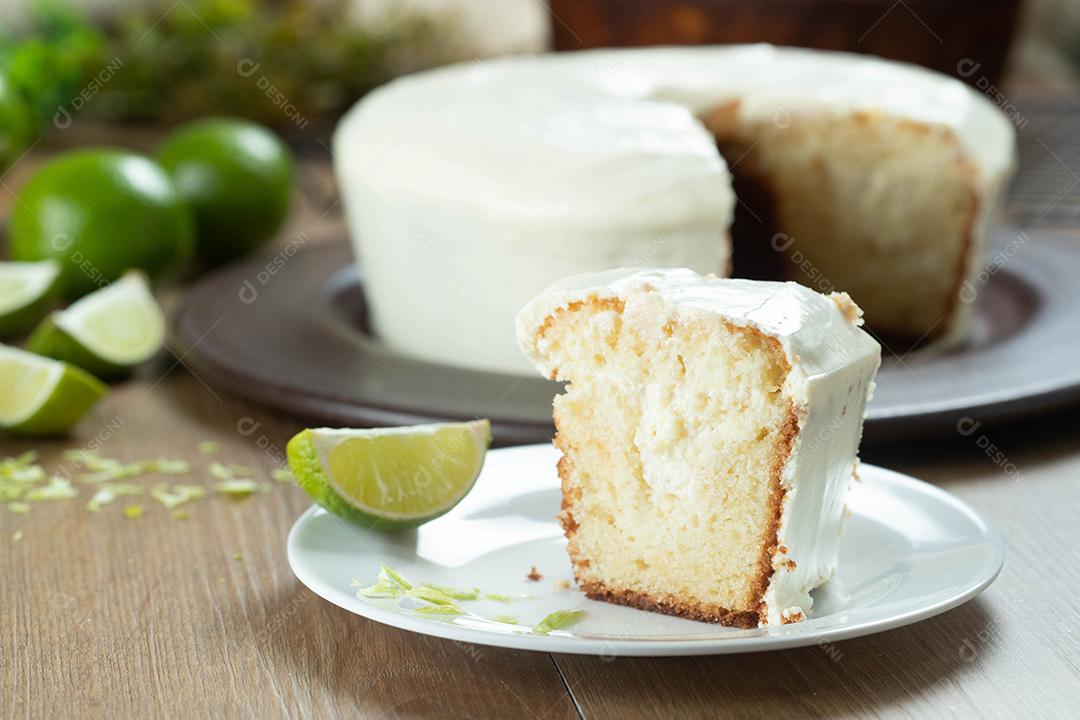 Feche o pedaço de bolo de frutas de limão úmido no prato com rodelas de limão na mesa de madeira. Delicioso café da manhã, hora do chá tradicional. Receita de bolo de limão