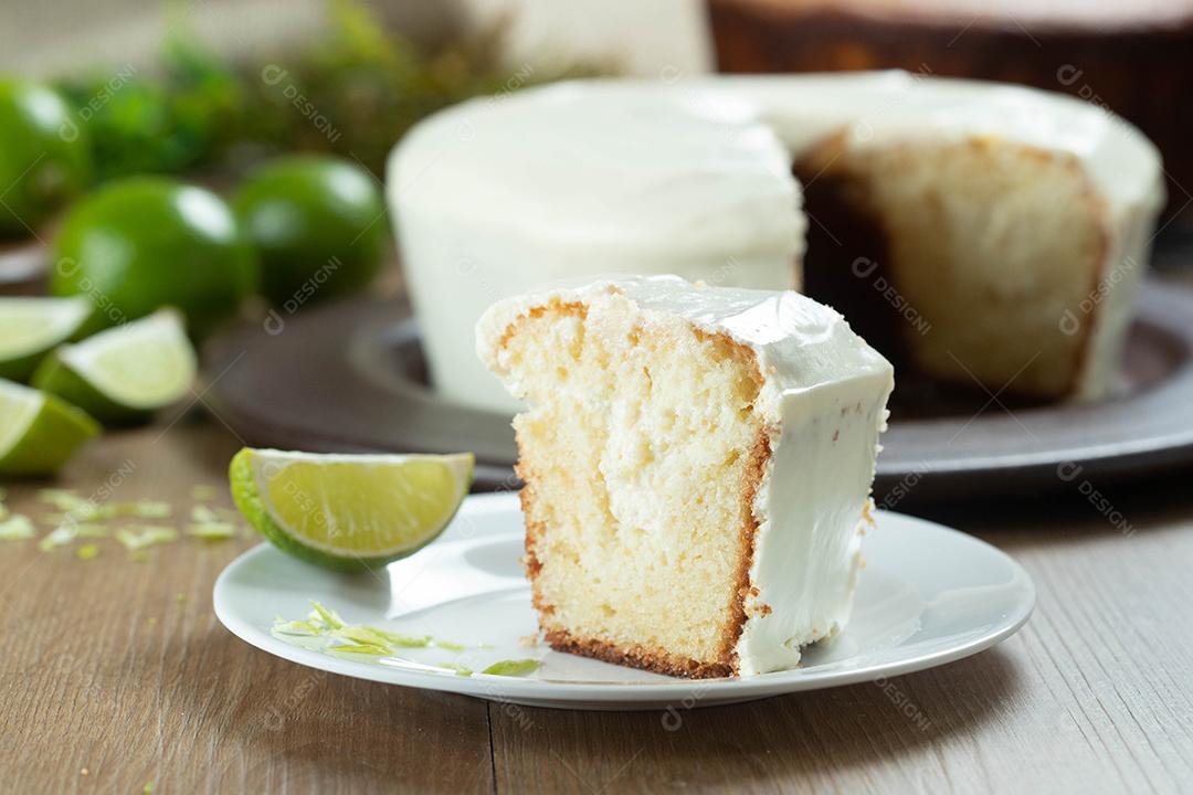 Piece of moist lemon fruitcake on plate with lemon slices on wooden table. Delicious breakfast, traditional tea time. Lemon cake recipe.