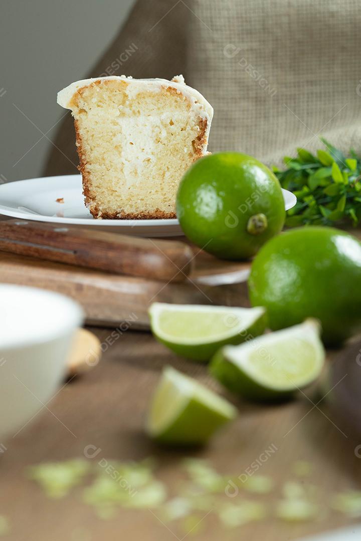Pedaço de bolo de frutas de limão úmido no prato com rodelas de limão na mesa de madeira. Delicioso café da manhã, hora do chá tradicional. Receita de bolo de limão.