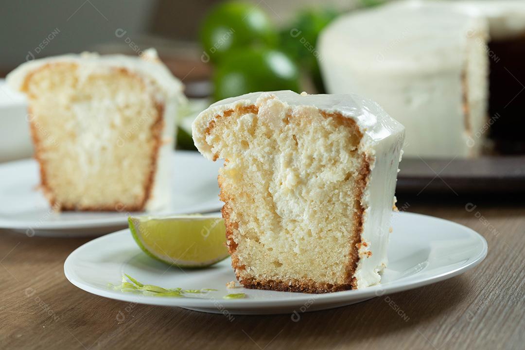 Pedaço de bolo de frutas de limão úmido no prato com rodelas de limão na mesa de madeira. Delicioso café da manhã, hora do chá tradicional. Receita de bolo de limão.