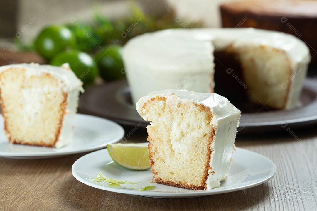 Pedaço de bolo de frutas de limão úmido no prato com rodelas de limão na mesa de madeira. Delicioso café da manhã, hora do chá tradicional. Receita de bolo de limão.