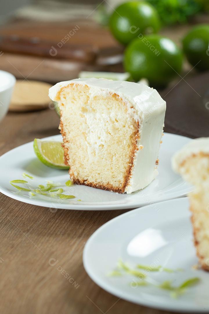 Pedaço de bolo de frutas de limão úmido no prato com rodelas de limão na mesa de madeira. Delicioso café da manhã, hora do chá tradicional. Receita de bolo de limão.