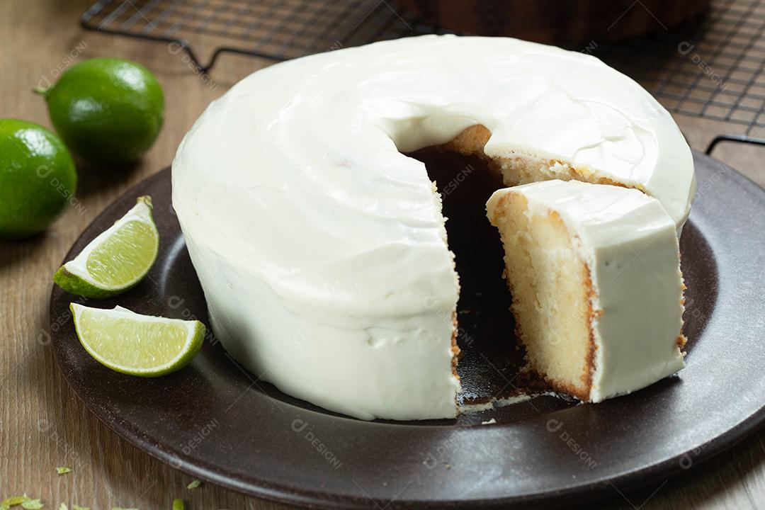 Feche o pedaço de bolo de frutas de limão úmido no prato com rodelas de limão na mesa de madeira. Delicioso café da manhã, hora do chá tradicional. Receita de bolo de limão