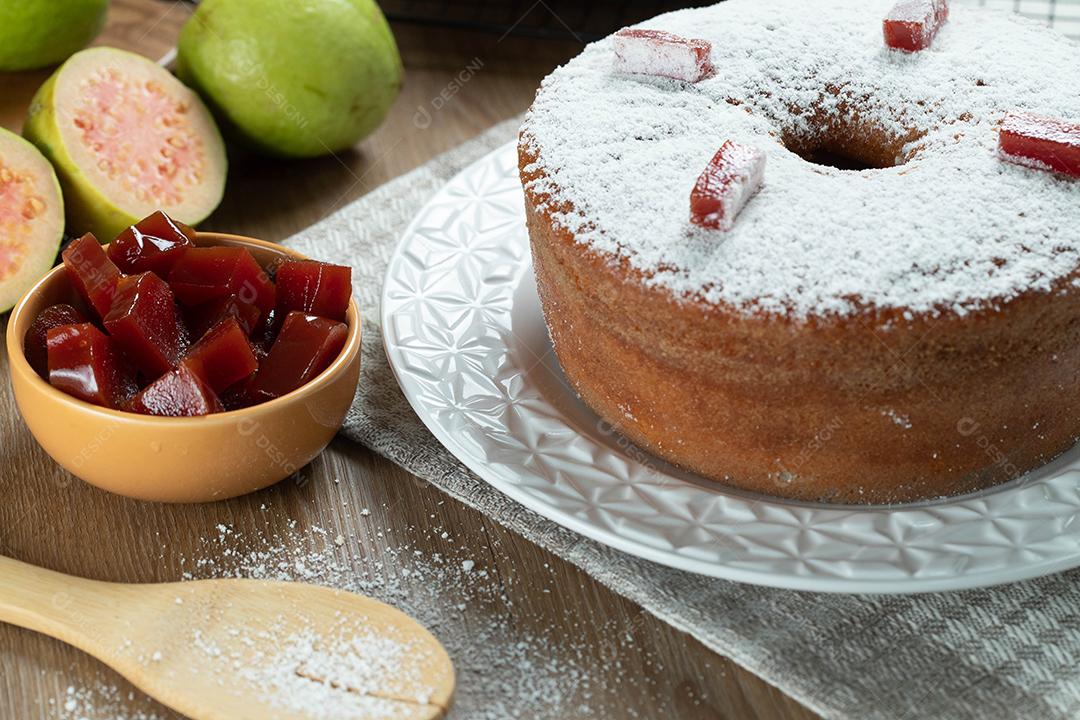 Bolo de milho brasileiro feito com um tipo de farinha de milho (Fuba) recheado com goiabada. Em uma mesa de festa de madeira. Doces típicos da festa junina. bolo de fubá