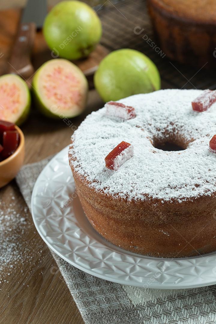 Bolo de milho brasileiro feito com um tipo de farinha de milho (Fuba) recheado com goiabada. Em uma mesa de festa de madeira. Doces típicos da festa junina. bolo de fubá