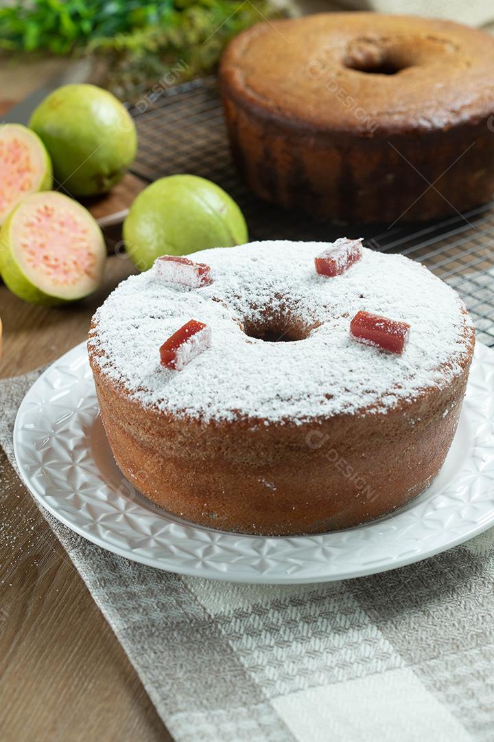 Bolo de milho brasileiro feito com um tipo de farinha de milho (Fuba) recheado com goiabada. Em uma mesa de festa de madeira. Doces típicos da festa junina. bolo de fubá