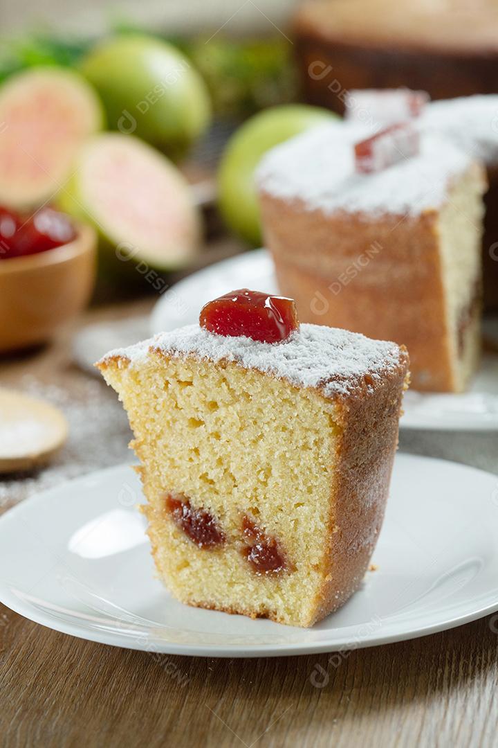 Feche o pedaço de bolo de milho brasileiro feito com um tipo de farinha de milho (Fuba) recheada com goiabada. Em uma mesa de festa de madeira. Doces típicos da festa junina. bolo de fubá