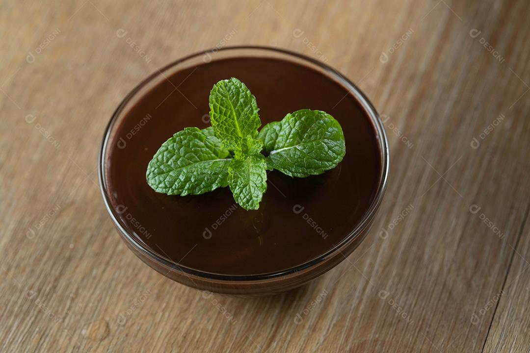 mousse de molho de chocolate com hortelã em frasco de vidro na mesa de madeira