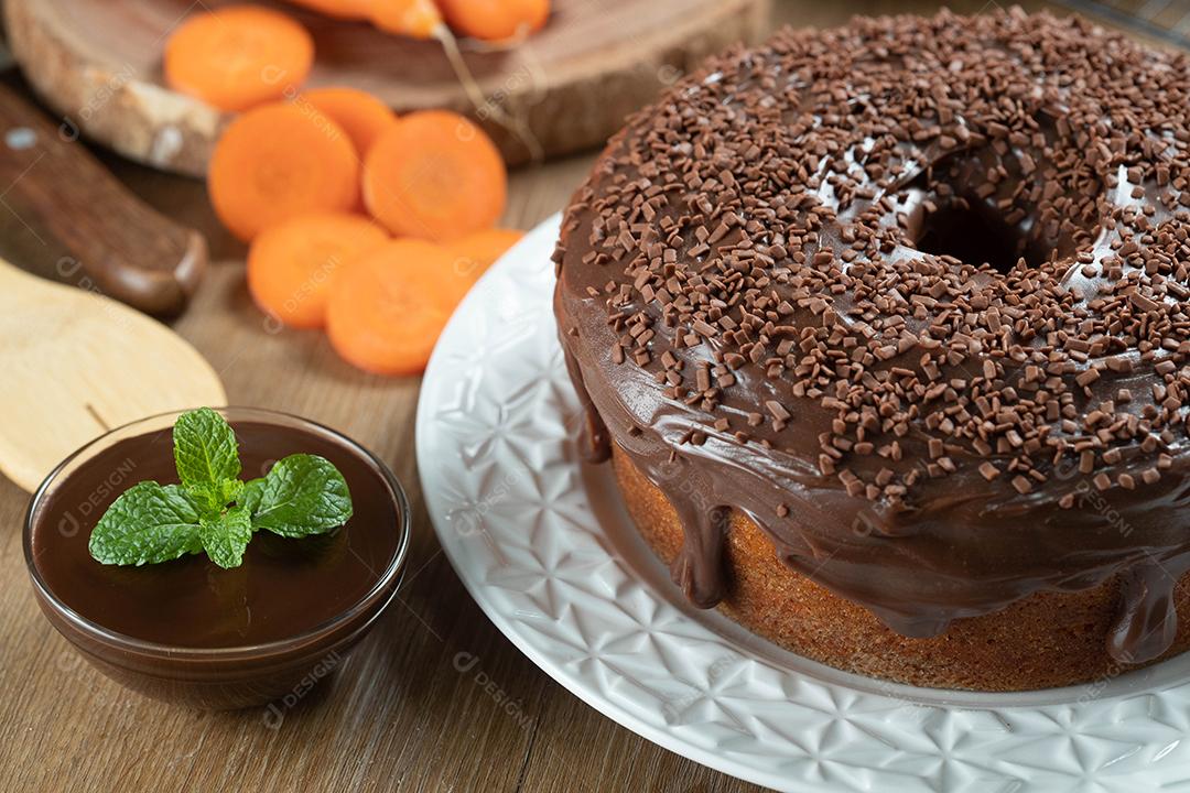 Bolo de cenoura brasileiro com cobertura de chocolate na mesa de madeira