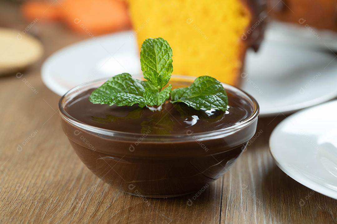 mousse de molho de chocolate com hortelã em frasco de vidro na mesa de madeira