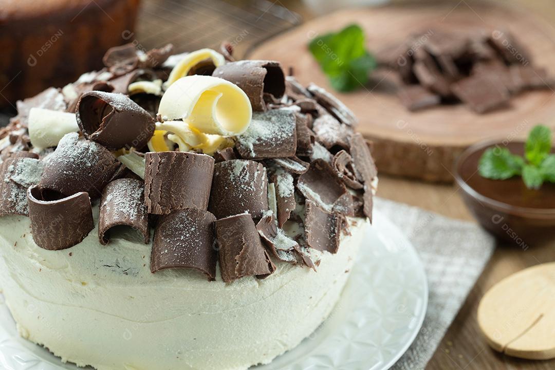 Chocolate branco e bolo de chocolate escuro dois amores na mesa de madeira. Bolo de aniversário e casamento.