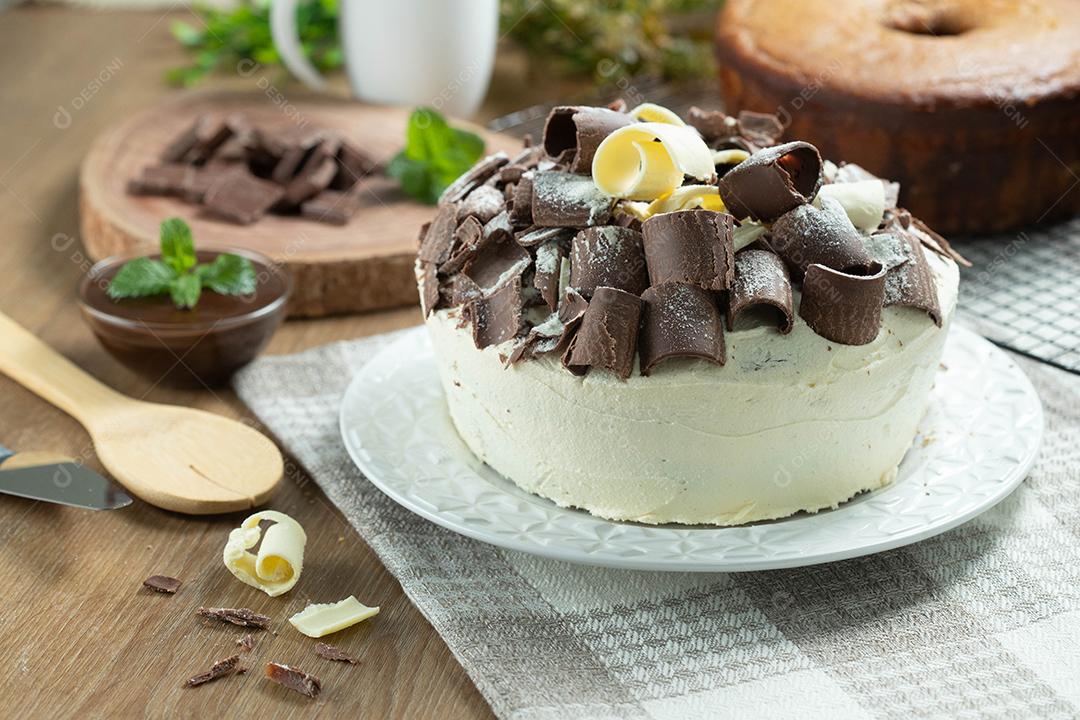 Chocolate branco e bolo de chocolate escuro dois amores na mesa de madeira. Bolo de aniversário e casamento.