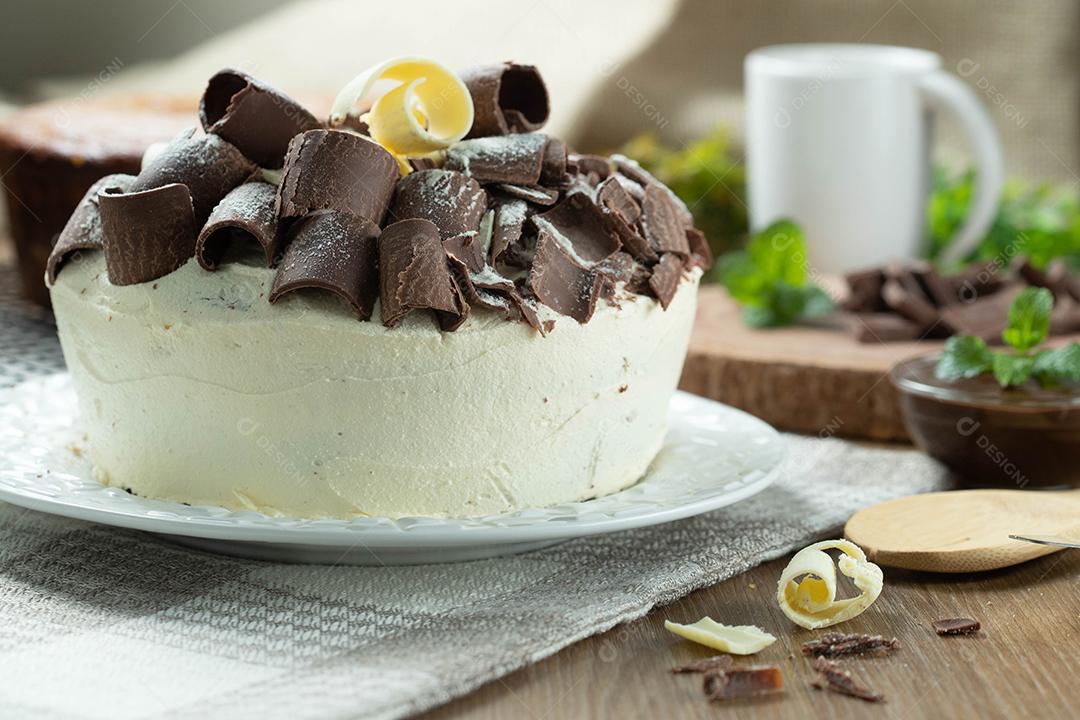 Chocolate branco e bolo de chocolate escuro dois amores na mesa de madeira. Bolo de aniversário e casamento.
