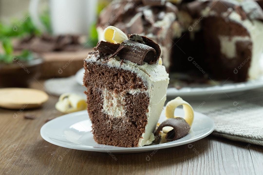 Feche o pedaço de chocolate branco e bolo de chocolate escuro dois amores na mesa de madeira. Bolo de aniversário e casamento.