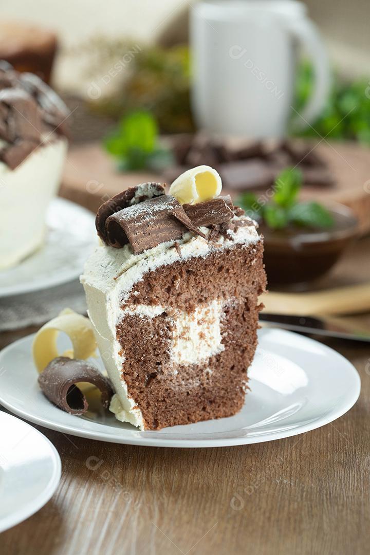 Feche o pedaço de chocolate branco e bolo de chocolate escuro dois amores na mesa de madeira. Bolo de aniversário e casamento.