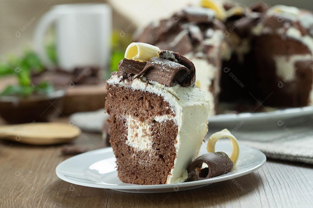Feche o pedaço de chocolate branco e bolo de chocolate escuro dois amores na mesa de madeira. Bolo de aniversário e casamento.