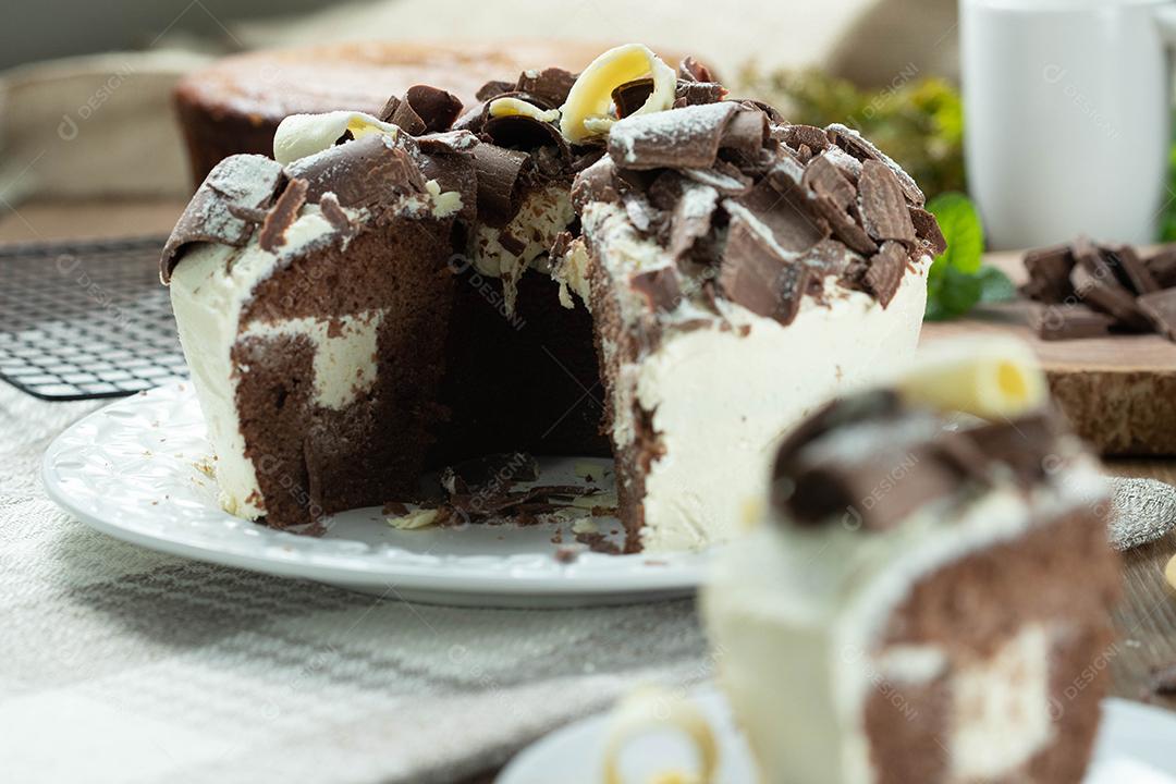 Feche o pedaço de chocolate branco e bolo de chocolate escuro dois amores na mesa de madeira. Bolo de aniversário e casamento.