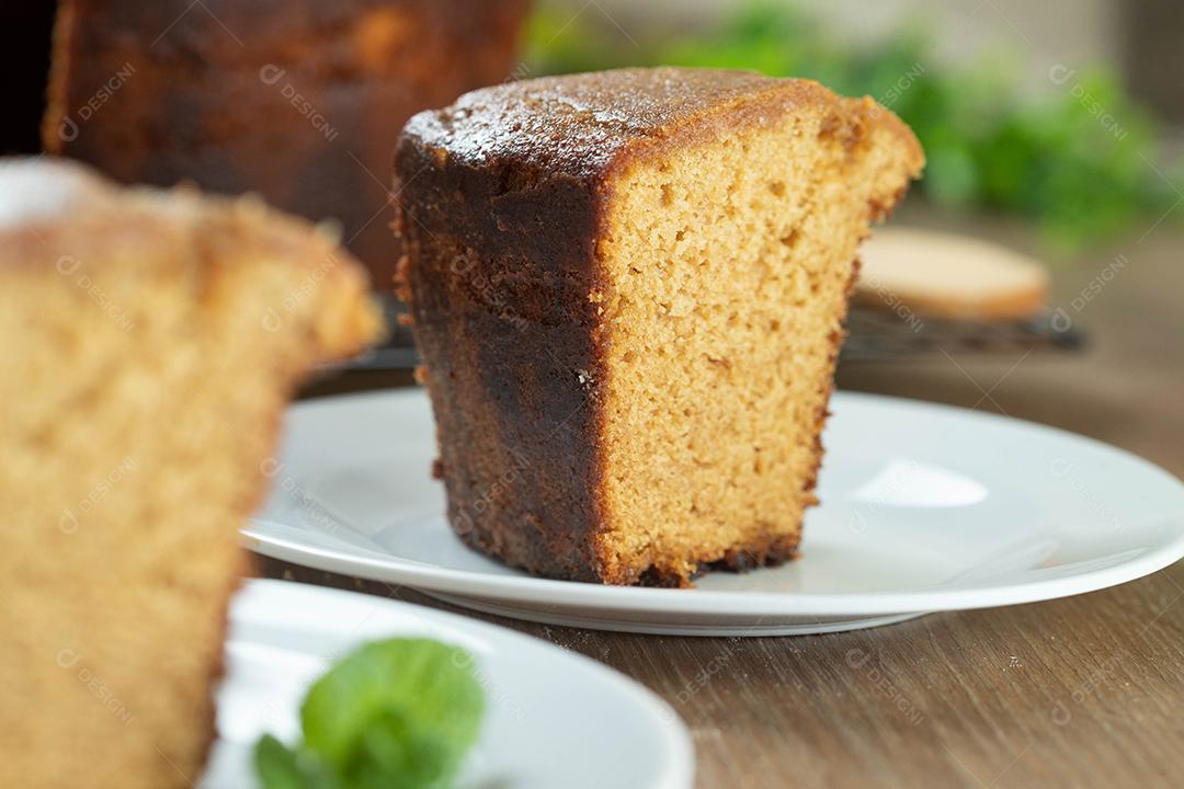 Feche o pedaço de bolo de milho brasileiro feito com um tipo de farinha de milho (Fuba). Em uma mesa de festa de madeira. Doces típicos da festa junina. Bolo de fubá.