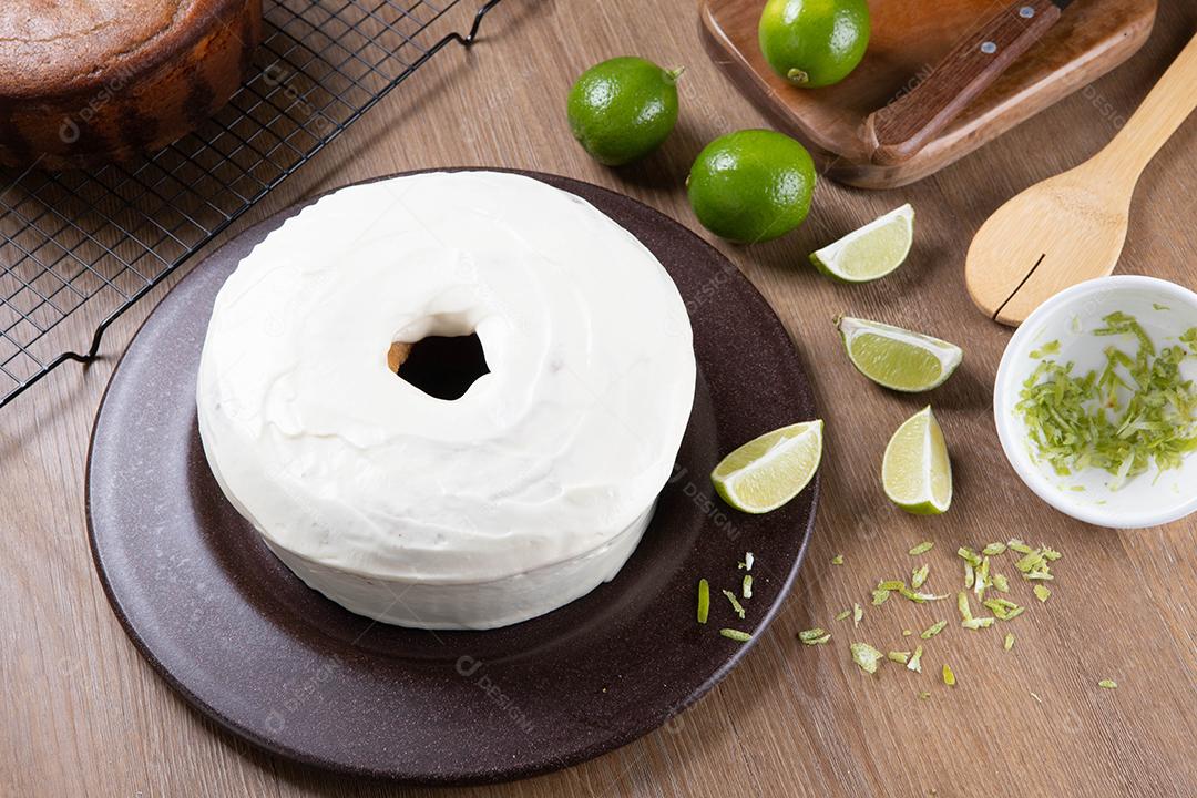 Bolo de frutas de limão úmido no prato com rodelas de limão na mesa de madeira. Delicioso café da manhã, hora do chá tradicional. Receita de bolo de limão. Vista do topo