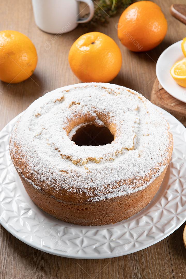 Bolo úmido de frutas laranja no prato com fatias de laranja na mesa de madeira. Delicioso café da manhã, hora do chá tradicional inglês. Receita de bolo de laranja.