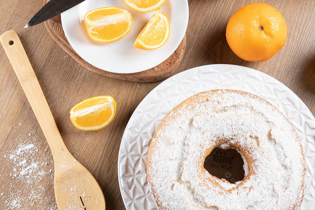 Bolo úmido de frutas laranja no prato com fatias de laranja na mesa de madeira. Delicioso café da manhã, hora do chá tradicional inglês. Receita de bolo de laranja.
