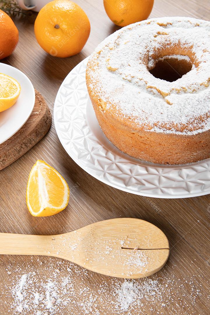 Bolo úmido de frutas laranja no prato com fatias de laranja na mesa de madeira. Delicioso café da manhã, hora do chá tradicional inglês. Receita de bolo de laranja.