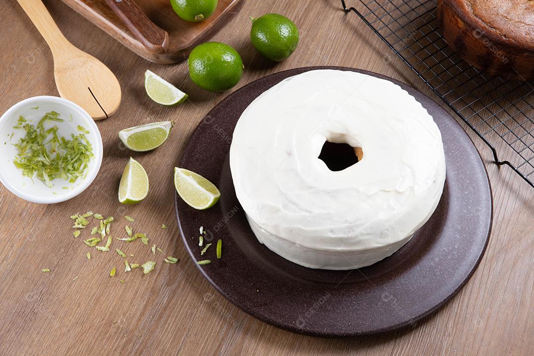 Bolo de frutas de limão úmido no prato com rodelas de limão na mesa de madeira. Delicioso café da manhã, hora do chá tradicional. Receita de bolo de limão. Vista do topo