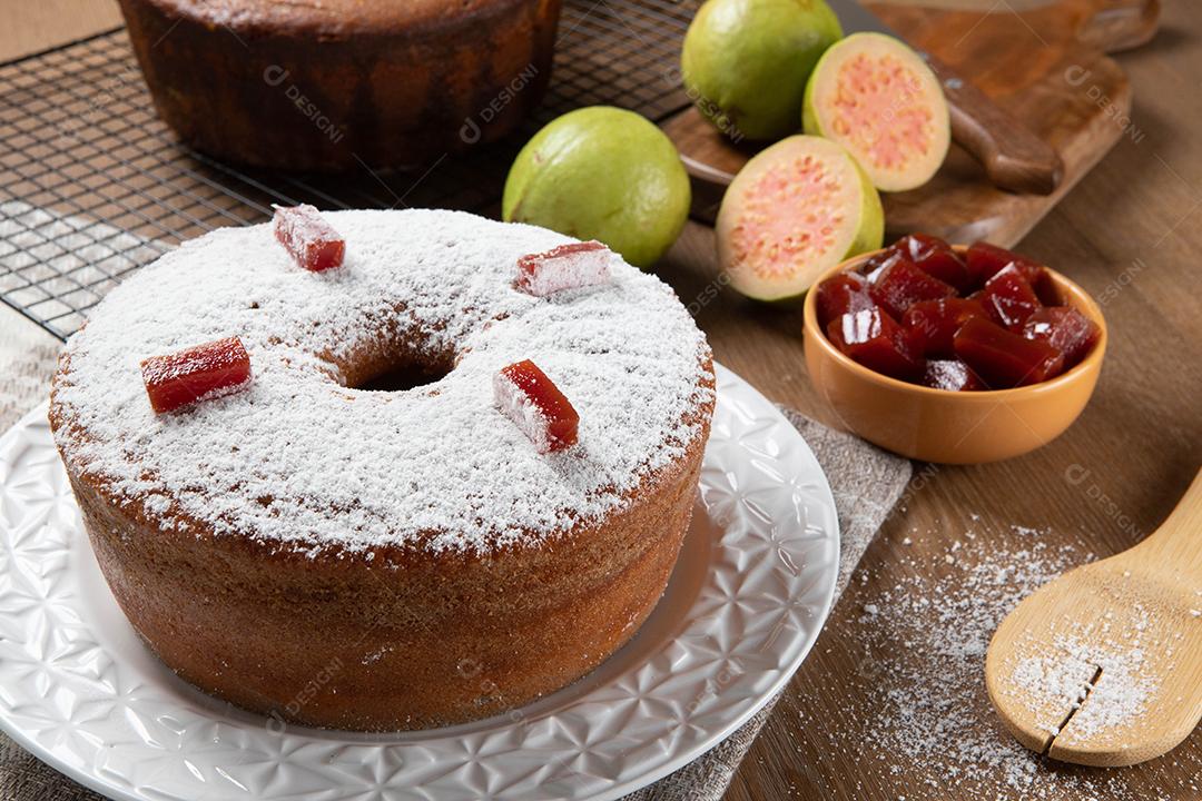 Bolo de milho brasileiro feito com um tipo de farinha de milho (Fuba) recheado com goiabada. Em uma mesa de festa de madeira. Doces típicos da festa junina. Bolo de fubá.
