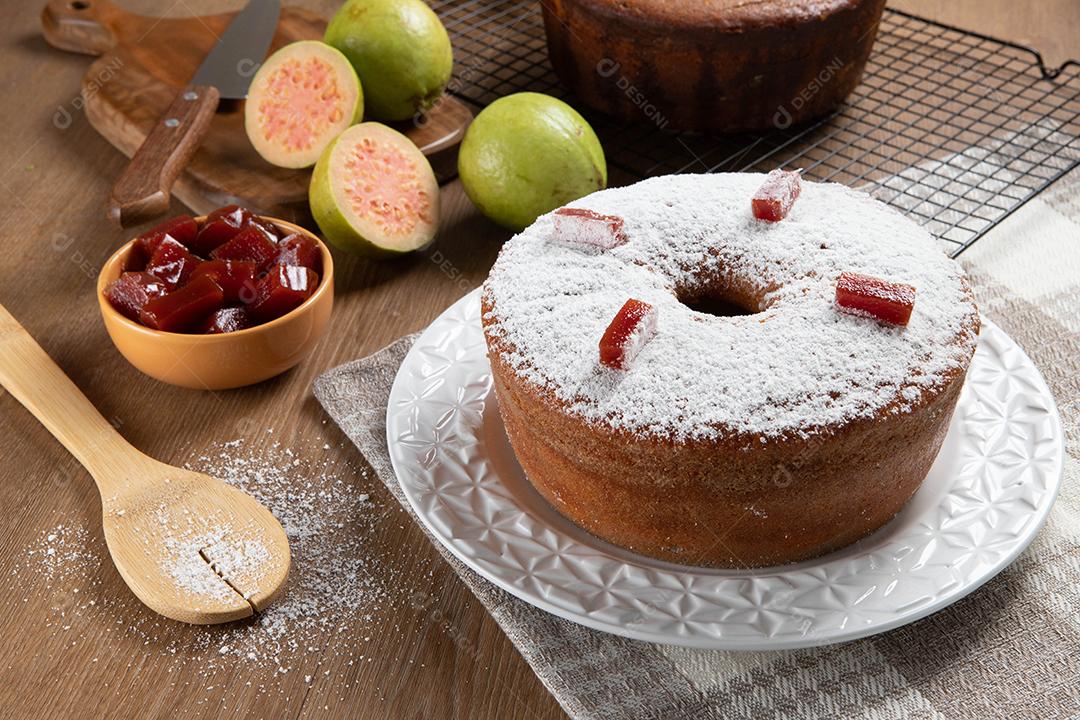 Bolo de milho brasileiro feito com um tipo de farinha de milho (Fuba) recheado com goiabada. Em uma mesa de festa de madeira. Doces típicos da festa junina. Bolo de fubá.