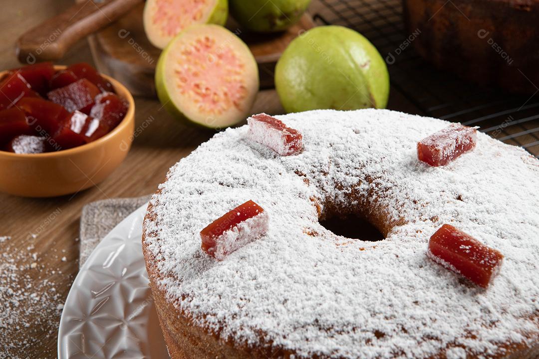 Bolo de milho brasileiro feito com um tipo de farinha de milho (Fuba) recheado com goiabada. Em uma mesa de festa de madeira. Doces típicos da festa junina. Bolo de fubá.