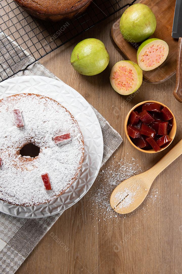 Bolo de milho brasileiro feito com um tipo de farinha de milho (Fuba) recheado com goiabada. Em uma mesa de festa de madeira. Doces típicos da festa junina. Bolo de fubá.