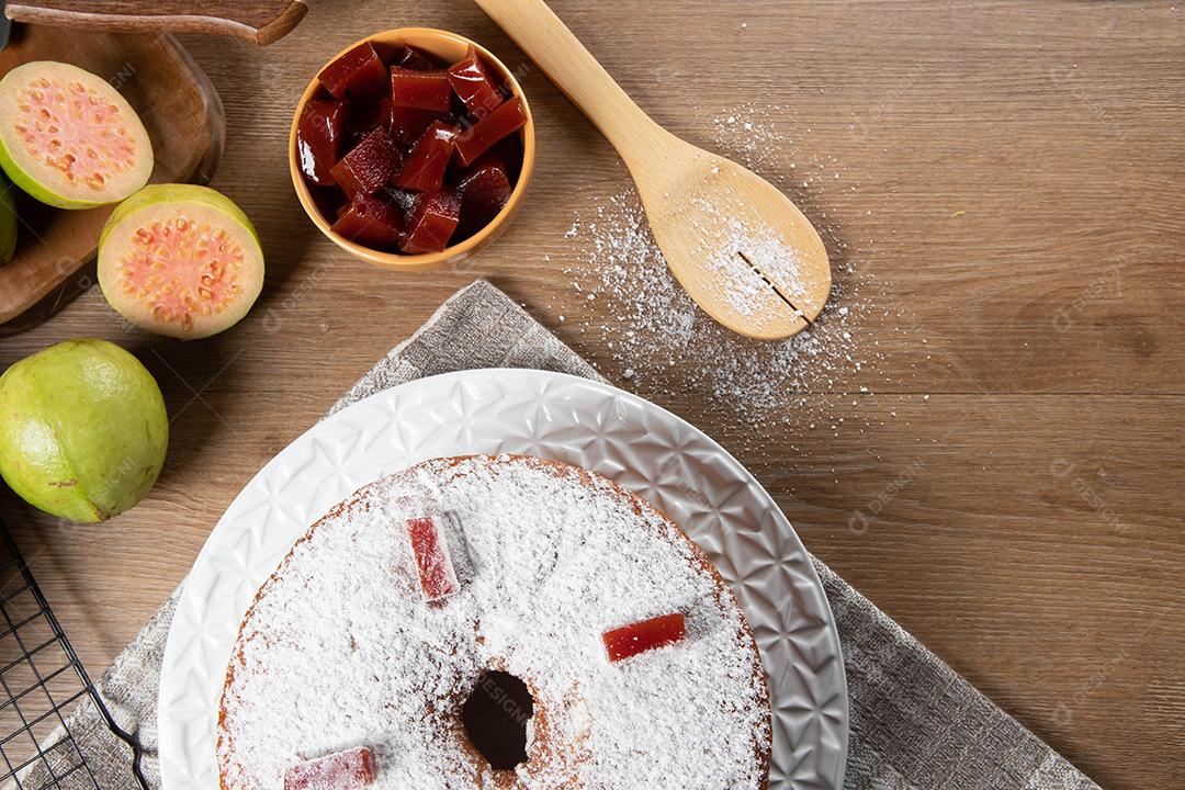 Bolo de milho brasileiro feito com um tipo de farinha de milho (Fuba) recheado com goiabada. Em uma mesa de festa de madeira. Doces típicos da festa junina. Bolo de fubá.