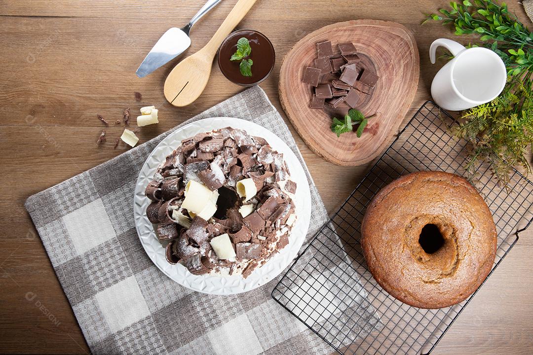 Chocolate branco e bolo de chocolate escuro dois amores na mesa de madeira. Bolo de aniversário e casamento. Vista do topo.