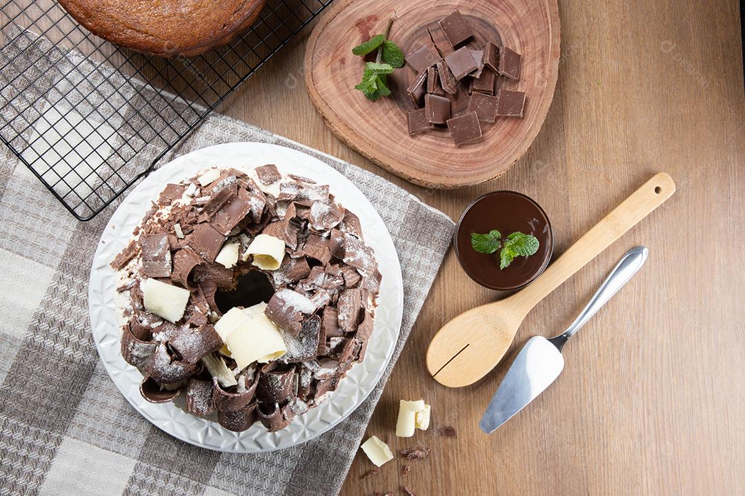 Chocolate branco e bolo de chocolate escuro dois amores na mesa de madeira. Bolo de aniversário e casamento. Vista do topo.