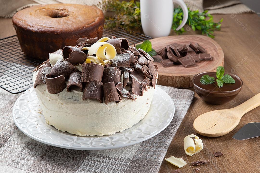 Chocolate branco e bolo de chocolate escuro dois amores na mesa de madeira. Bolo de aniversário e casamento.