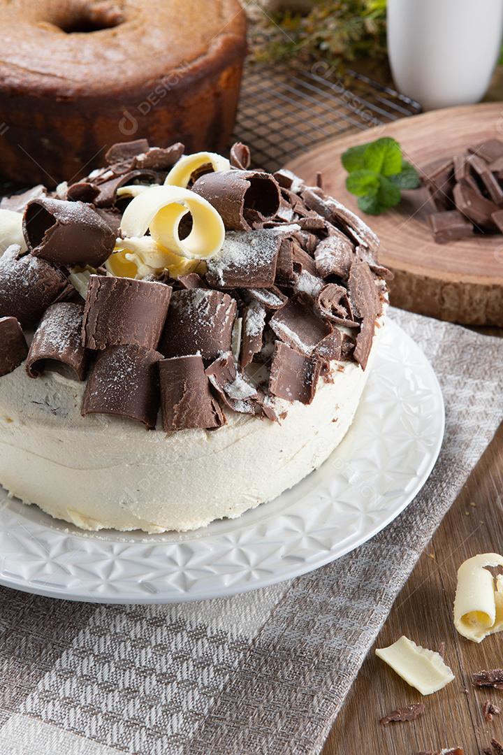 Chocolate branco e bolo de chocolate escuro dois amores na mesa de madeira. Bolo de aniversário e casamento.