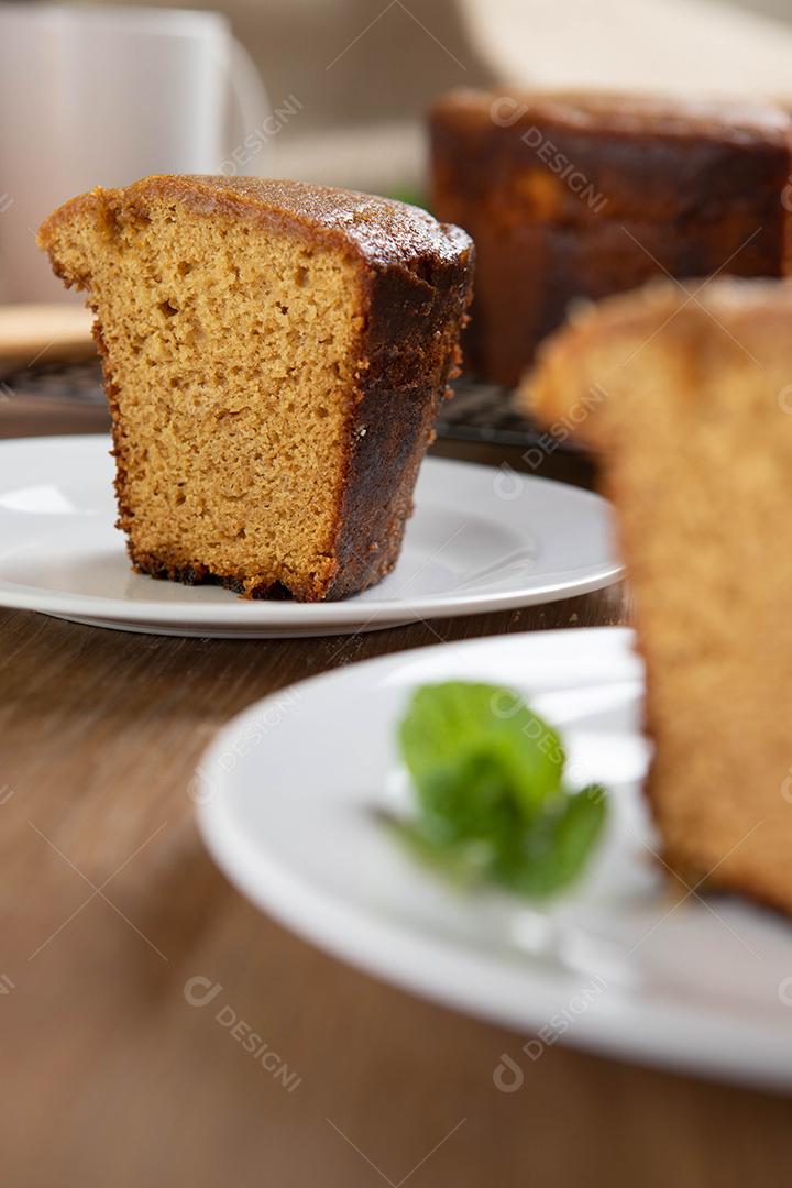 Feche o pedaço de bolo de milho brasileiro feito com um tipo de farinha de milho (Fuba). Em uma mesa de festa de madeira. Doces típicos da festa junina. Bolo de fubá.