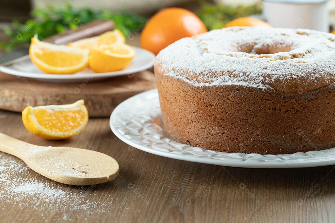 Bolo úmido de frutas laranja no prato com fatias de laranja na mesa de madeira. Delicioso café da manhã, hora do chá tradicional inglês. Receita de bolo de laranja.