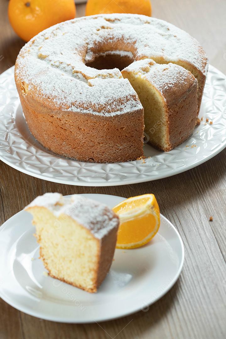 Pedaço de bolo de frutas laranja úmida no prato com fatias de laranja na mesa de madeira. Delicioso café da manhã, hora do chá tradicional inglês. Receita de bolo de laranja.