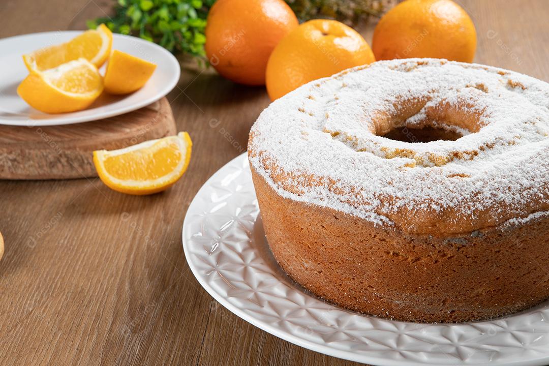 Bolo úmido de frutas laranja no prato com fatias de laranja na mesa de madeira. Delicioso café da manhã, hora do chá tradicional inglês. Receita de bolo de laranja.