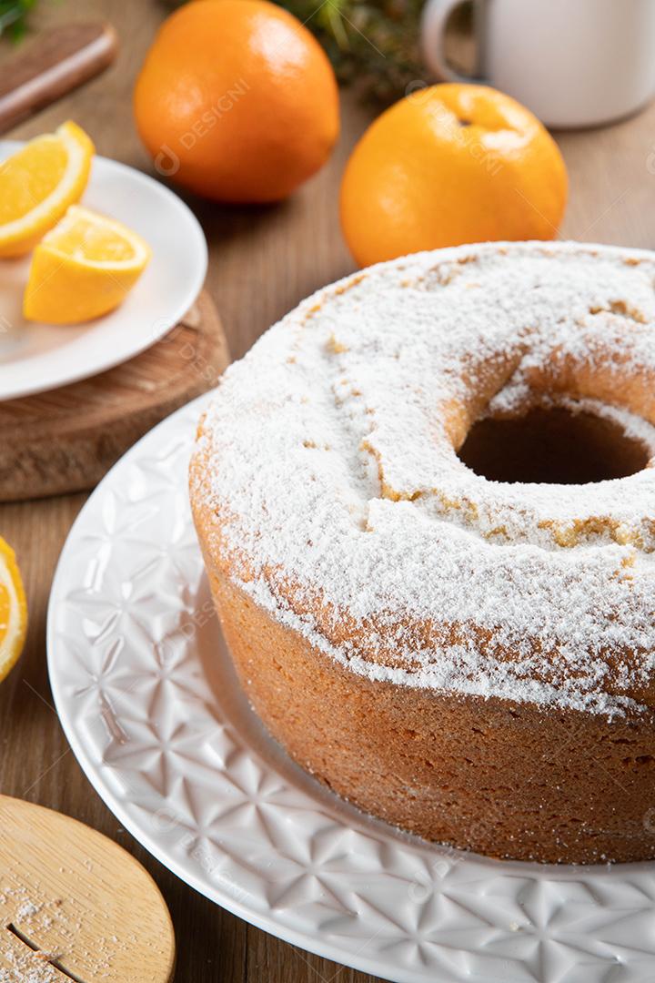 Bolo úmido de frutas laranja no prato com fatias de laranja na mesa de madeira. Delicioso café da manhã, hora do chá tradicional inglês. Receita de bolo de laranja.