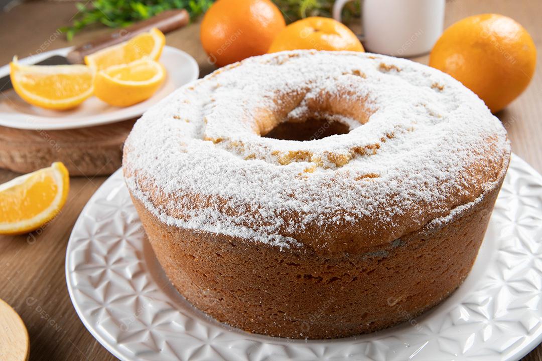 Bolo úmido de frutas laranja no prato com fatias de laranja na mesa de madeira. Delicioso café da manhã, hora do chá tradicional inglês. Receita de bolo de laranja.