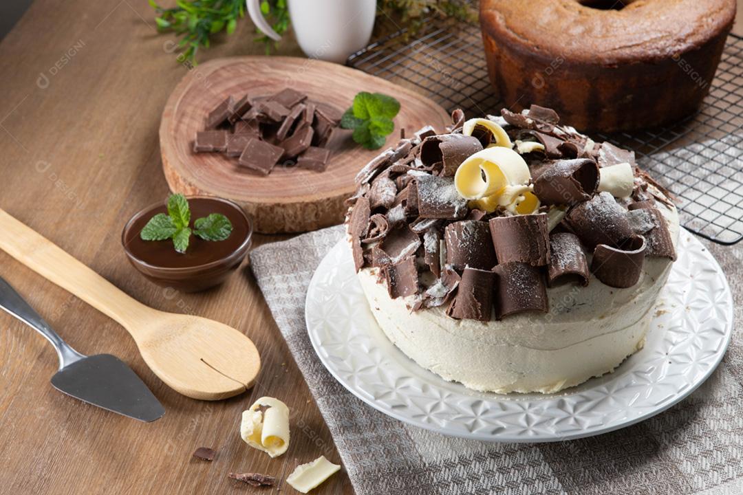 Chocolate branco e bolo de chocolate escuro dois amores na mesa de madeira