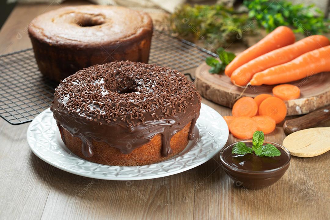 Bolo de cenoura brasileiro com cobertura de chocolate na mesa de madeira wi