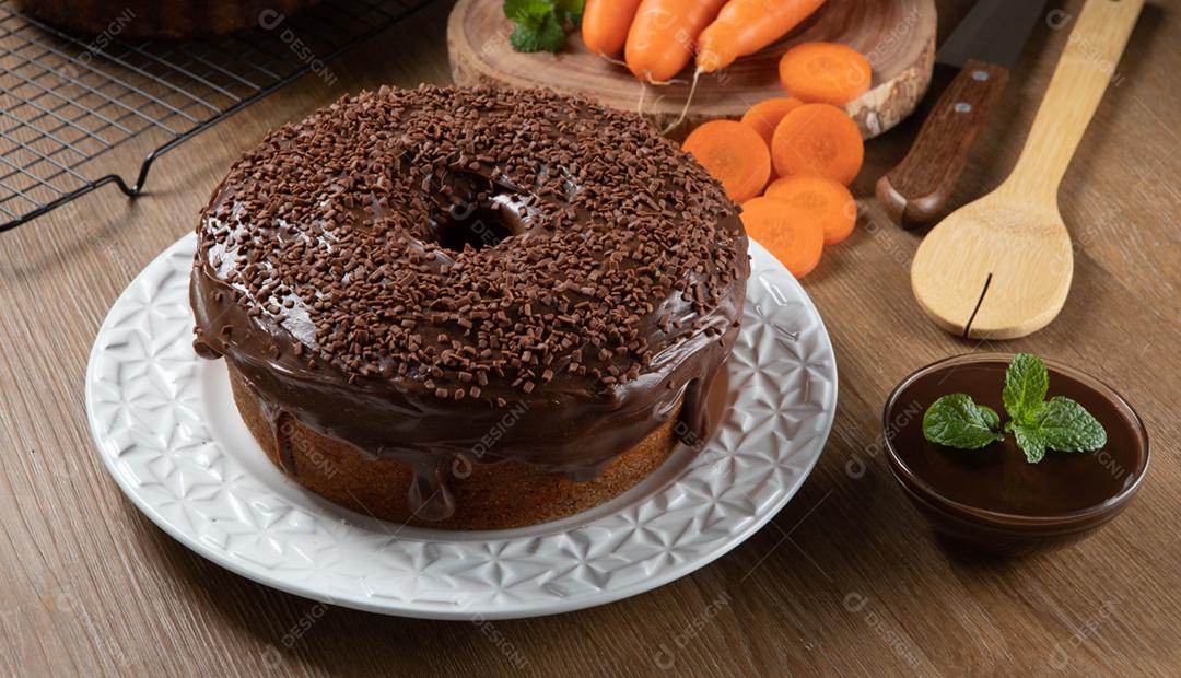 Bolo de cenoura brasileiro com cobertura de chocolate na mesa de madeira wi