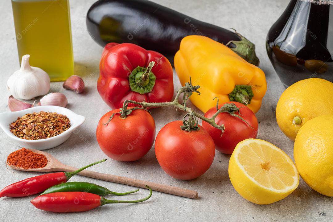 Tomate, pimentão, azeite, limão siciliano e alho sobre a mesa de madeira. Comida mediterrânea.