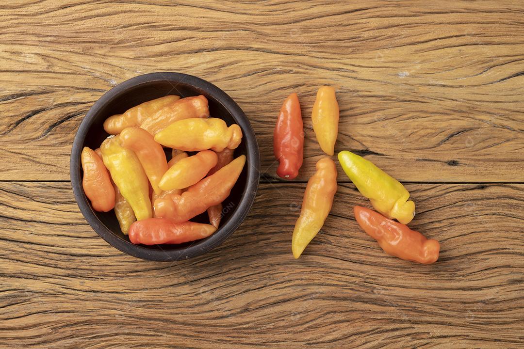 Pimenta laranja cheiro (cheiro) em uma tigela sobre a mesa de madeira.