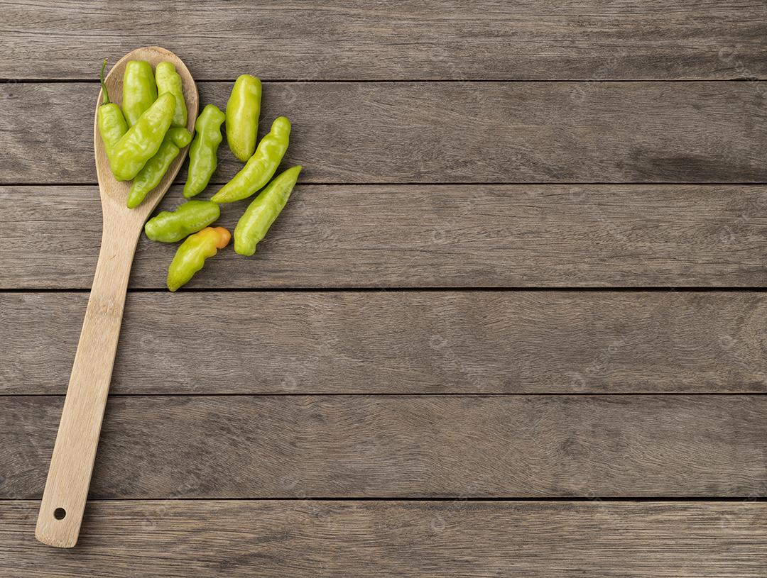 Pimentas verdes cheiro (cheiro, cheiro) em uma colher sobre a mesa de madeira com