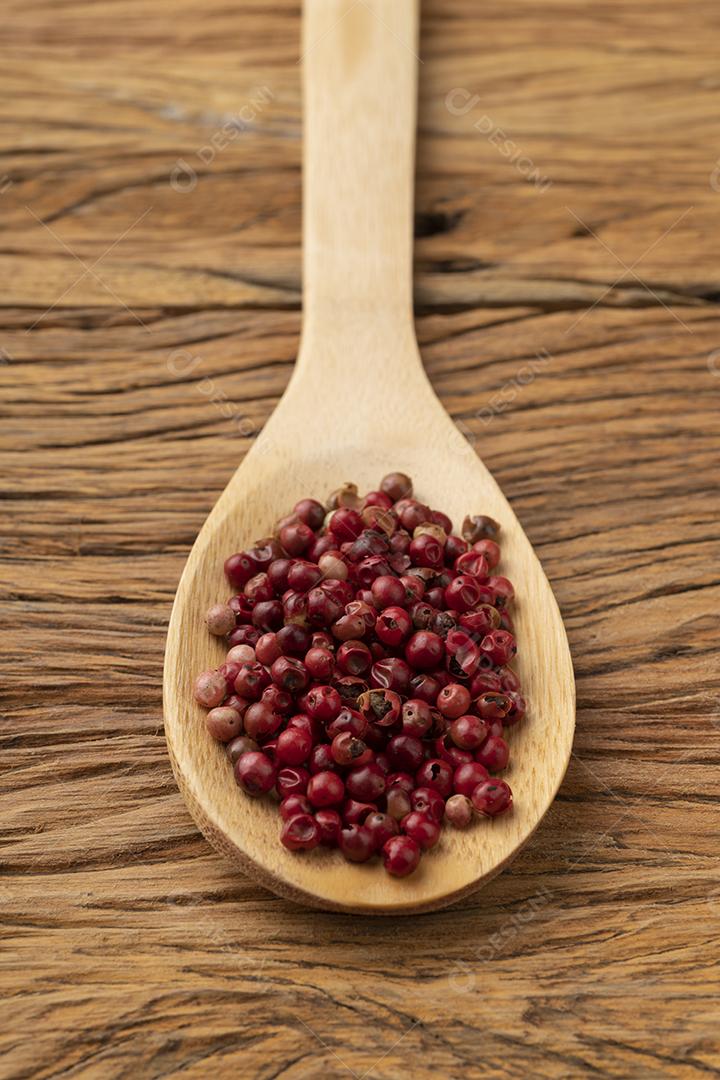 Grãos secos de pimenta vermelha em uma colher de pau. Cenário de comida.