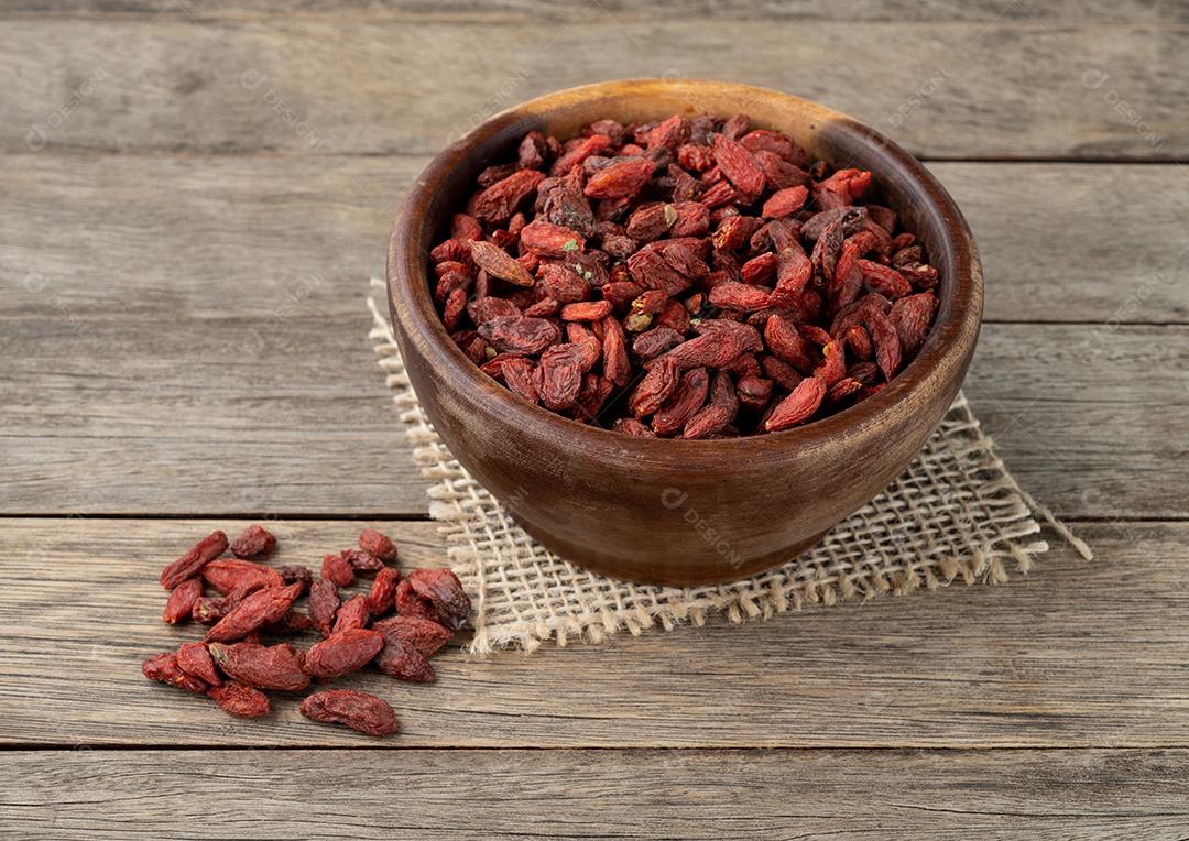 Goji berry em uma tigela sobre a mesa de madeira.